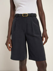 Person trägt dunkle Shorts mit Gürtel