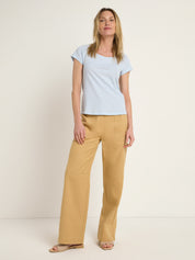 Frau in blauem Shirt und senfgelben Hosen