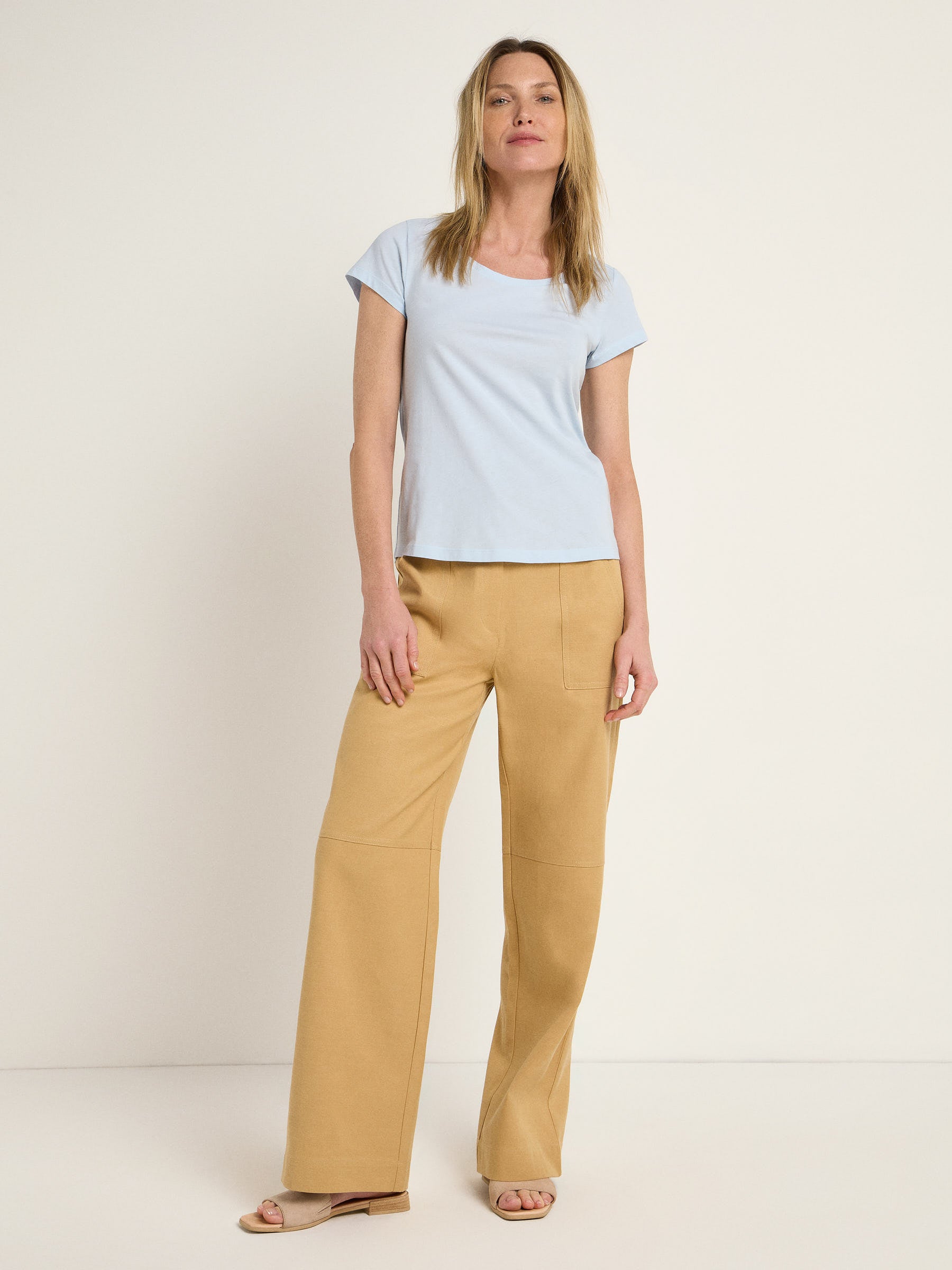 Frau in blauem Shirt und senfgelben Hosen