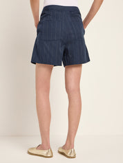 Marineblaue Shorts mit weißen Streifen und goldenen Schuhen