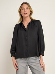 Frau in schwarzer Bluse und grauer Hose