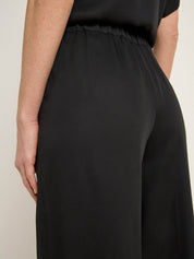 Frau in schwarzem Kleid seitlich