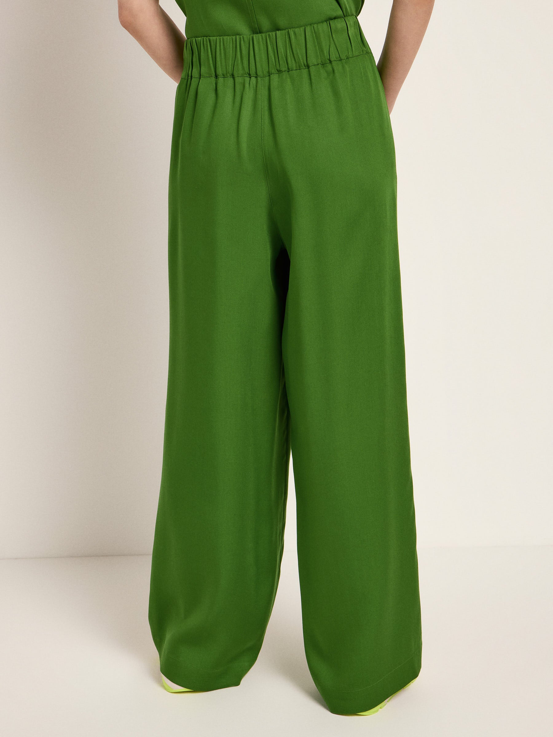 Person trägt grüne Hose, Rückansicht