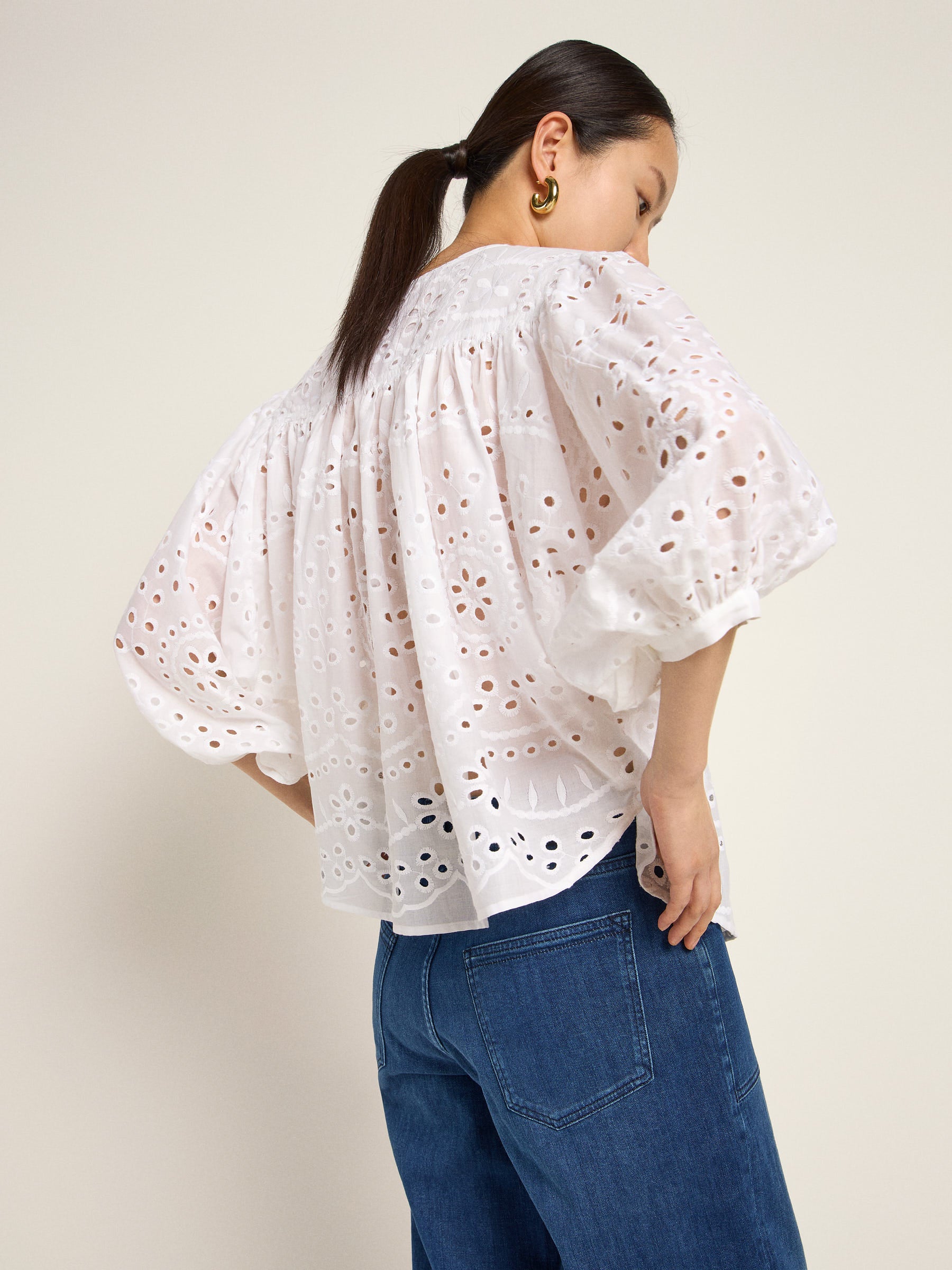 Frau trägt weiße Bluse und Jeans