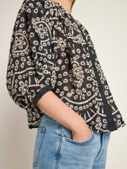 Frau trägt blumenbestickte Bluse und Jeans