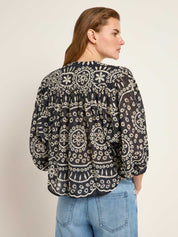 Frau in bestickter Bluse und Jeans