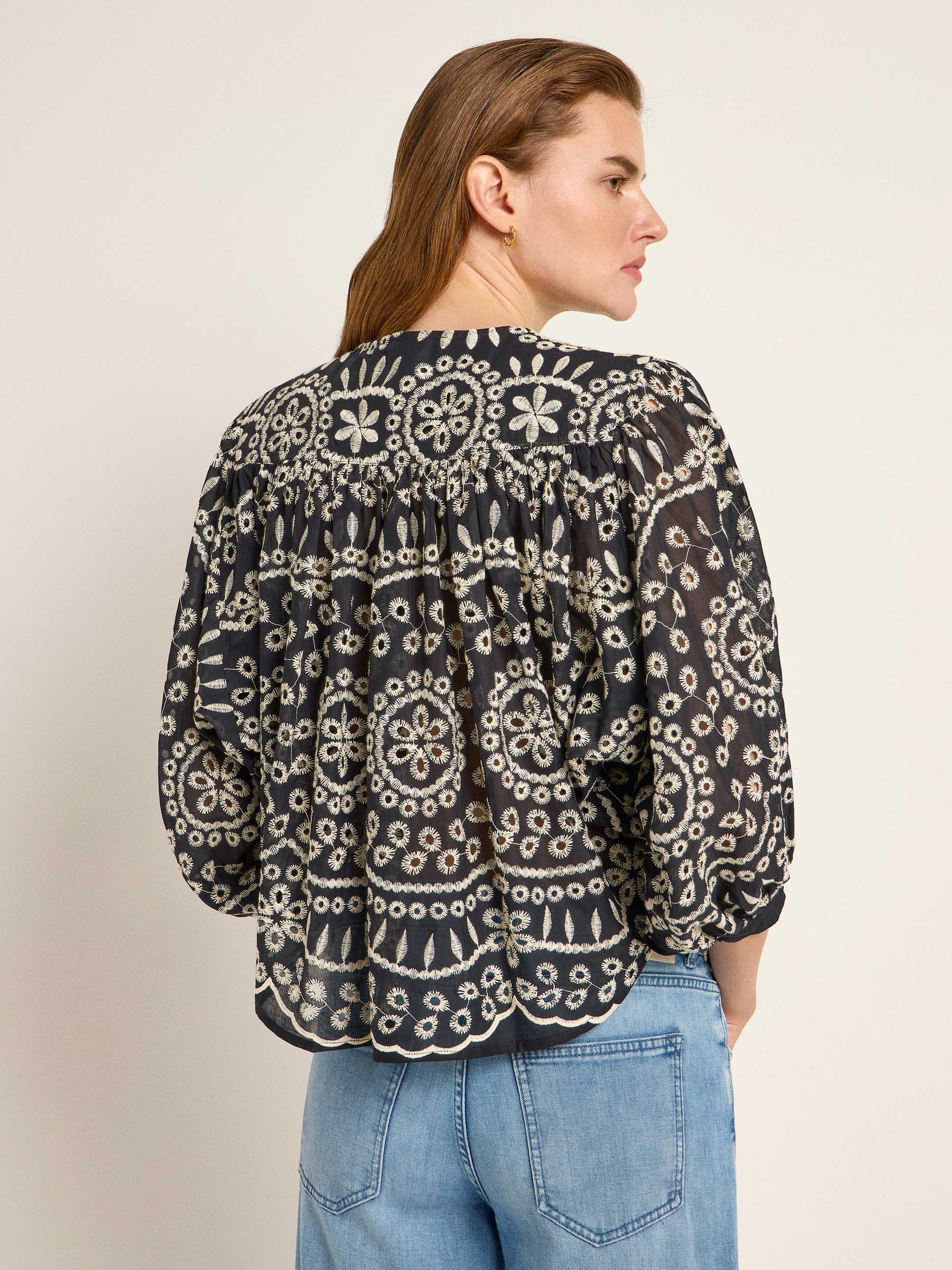 Frau in bestickter Bluse und Jeans