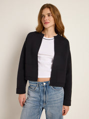 Frau in schwarzer Jacke und blauen Jeans