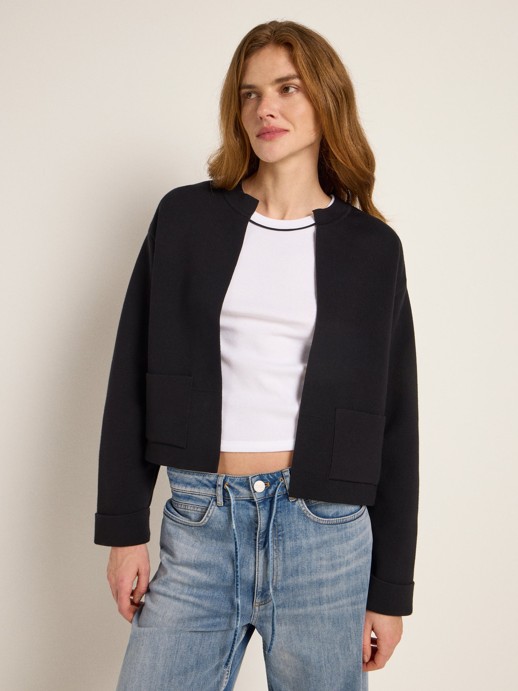 Frau in schwarzer Jacke und blauen Jeans