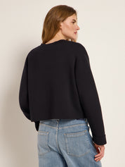 Frau in schwarzer Jacke und Jeans von hinten