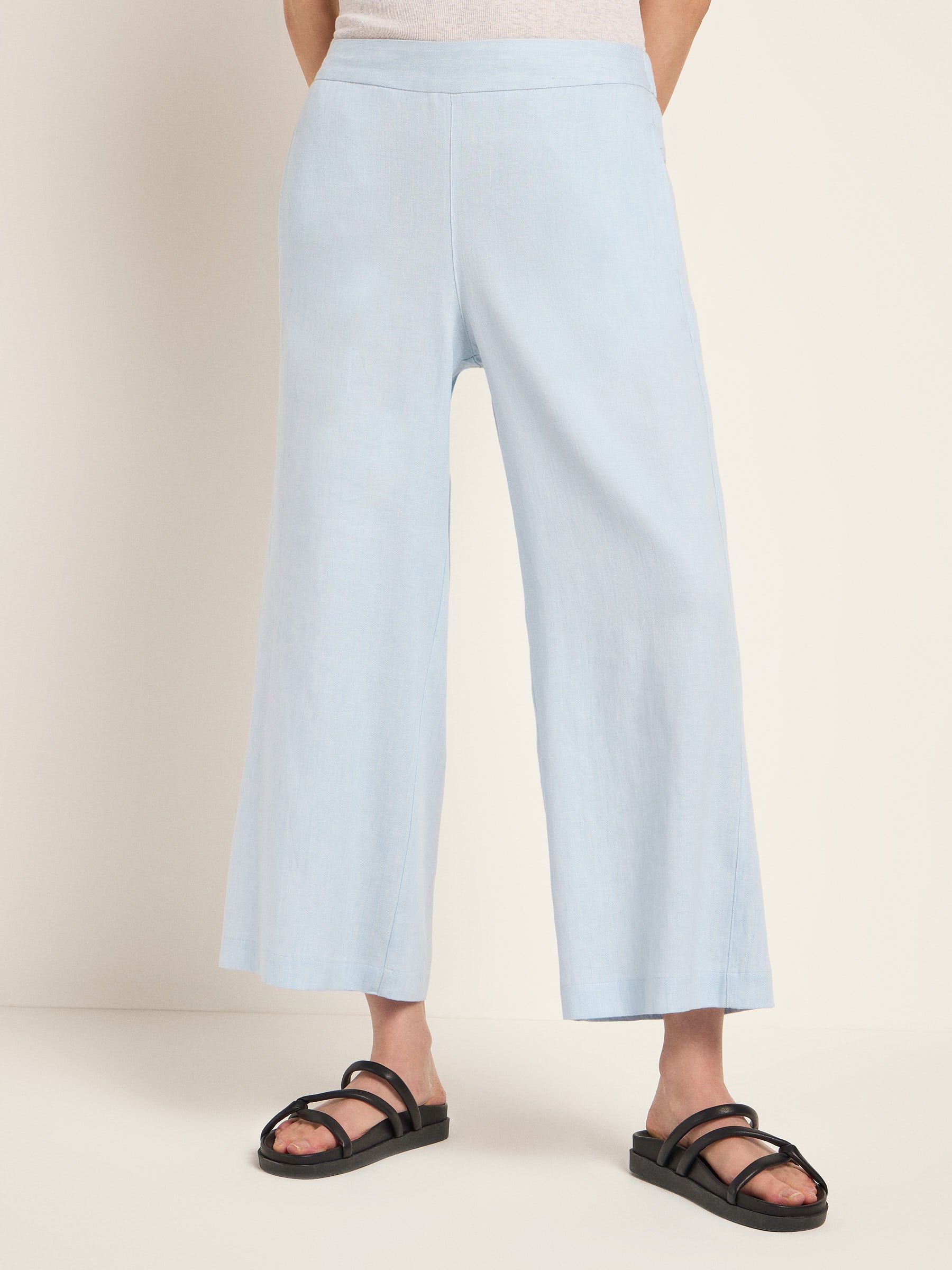 Frau in hellblauen Culottes und schwarzen Sandalen