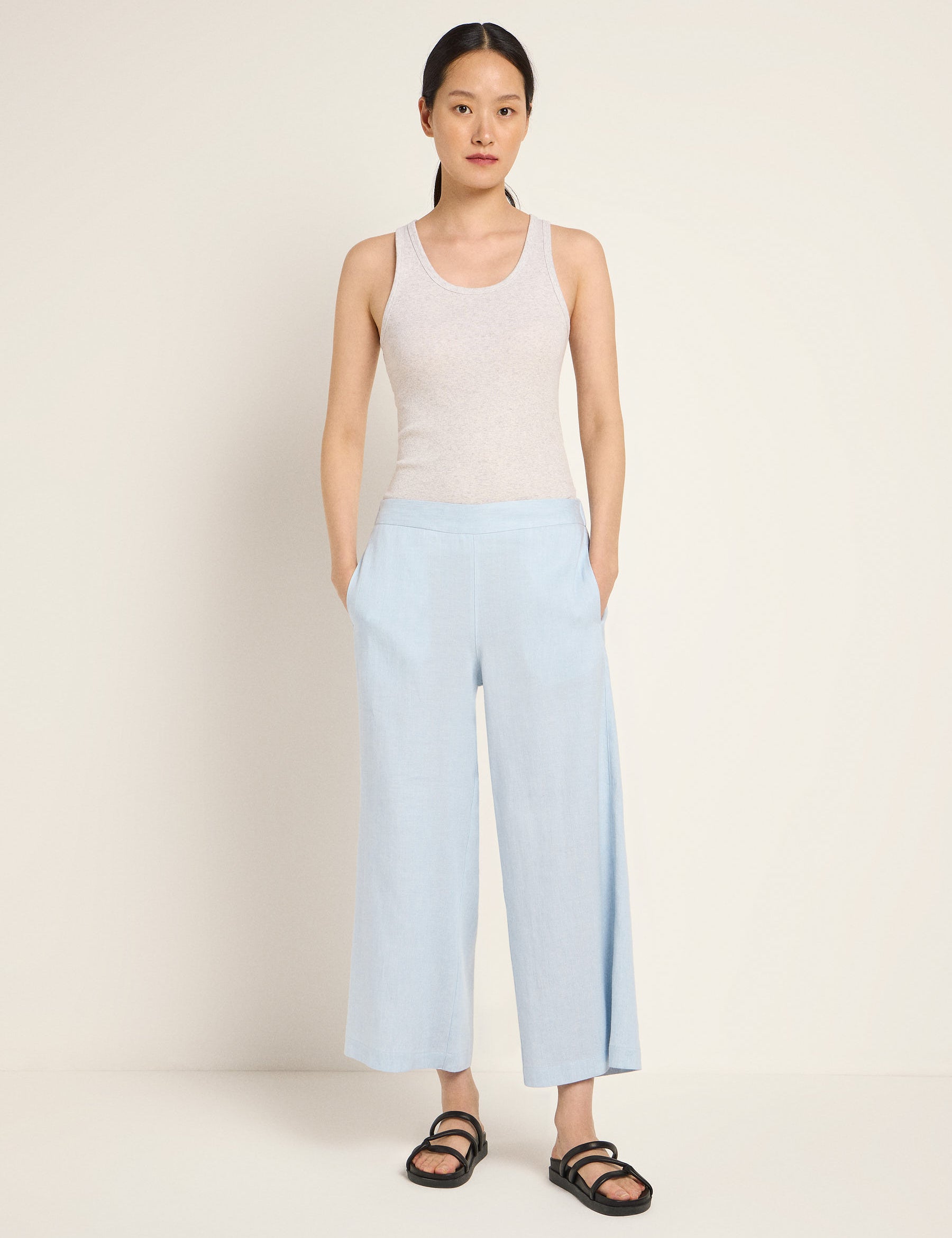 Frau in blauer Hose und grauem Top posiert