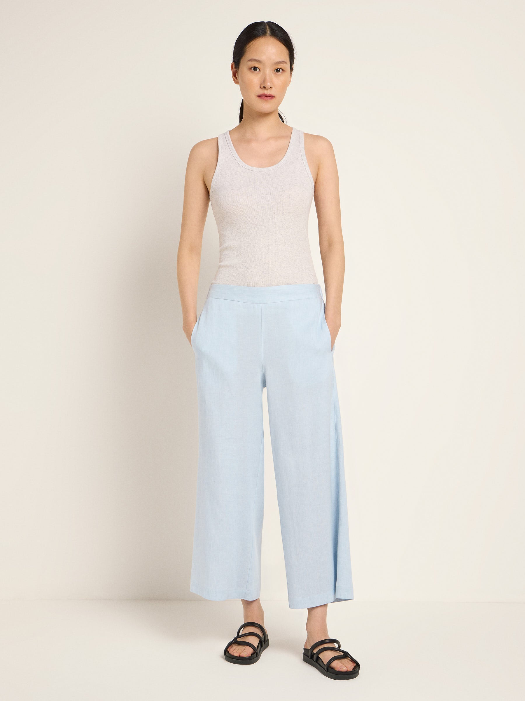 Frau in blauer Hose und grauem Top posiert