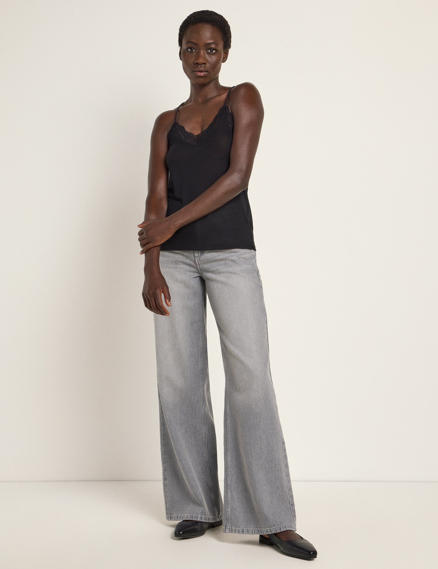 Frau in schwarzem Top und grauen Jeans