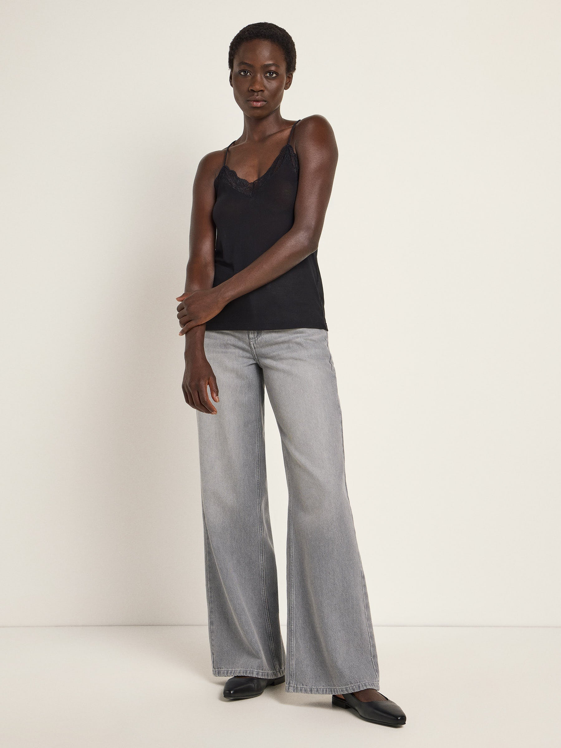 Frau in schwarzem Top und grauen Jeans