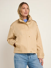 Frau in beiger Jacke und blauer Jeans