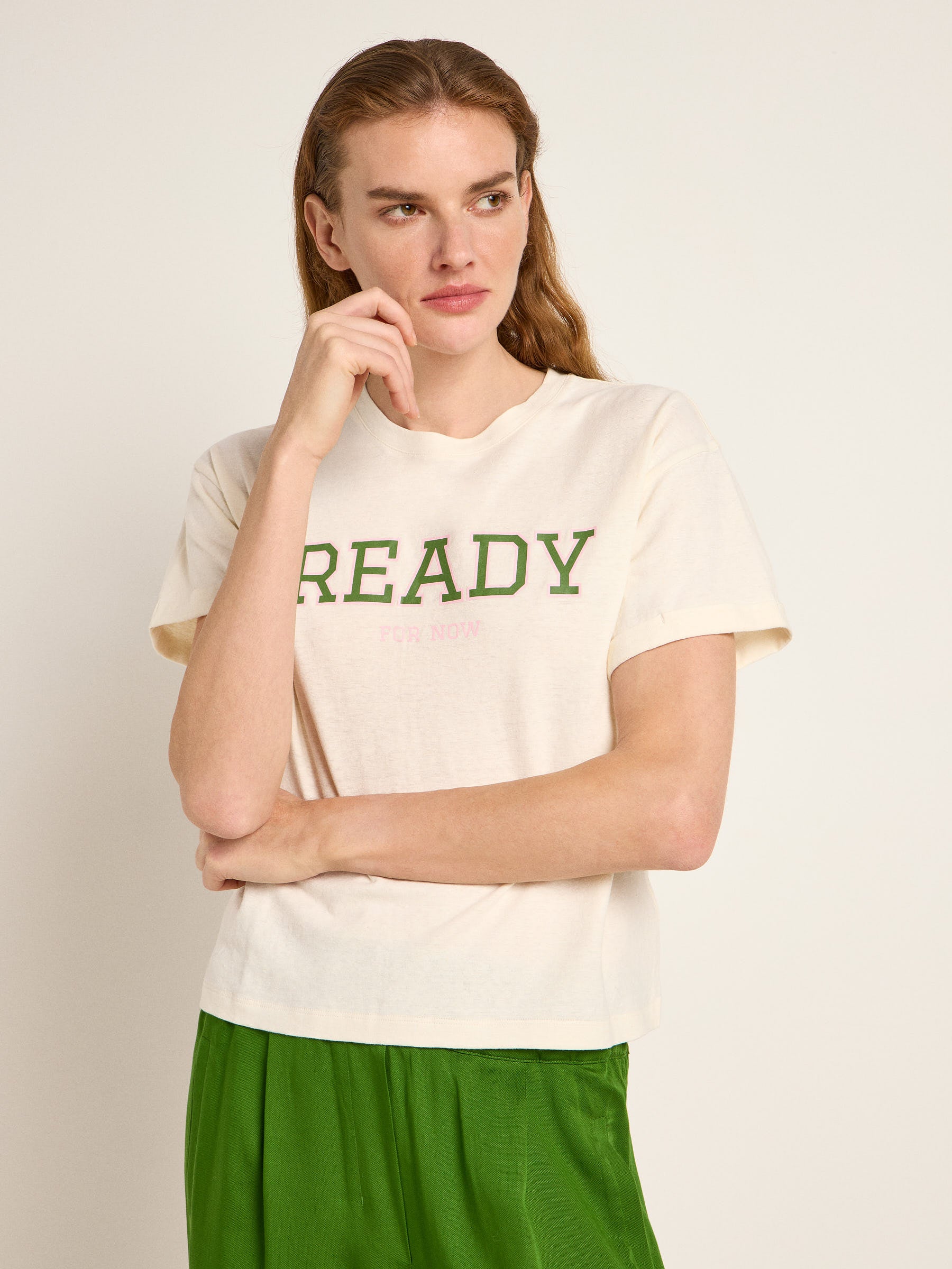 Frau in weißem Shirt und grüner Hose
