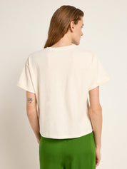 Frau von hinten in weißem T-Shirt und grüner Hose