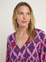 Frau in buntem Kleid mit ernstem Blick