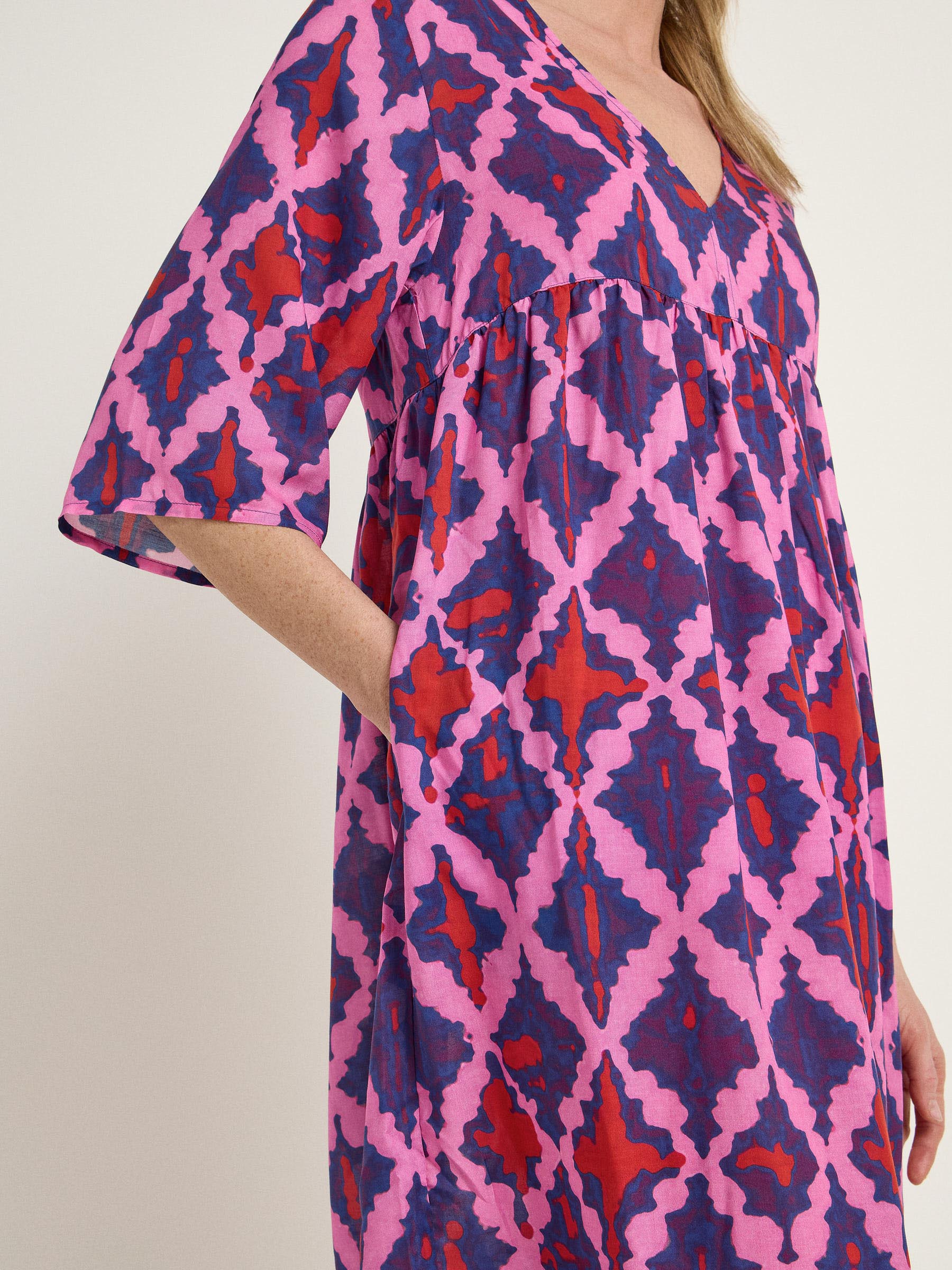 Frau trägt buntes Kleid mit geometrischem Muster