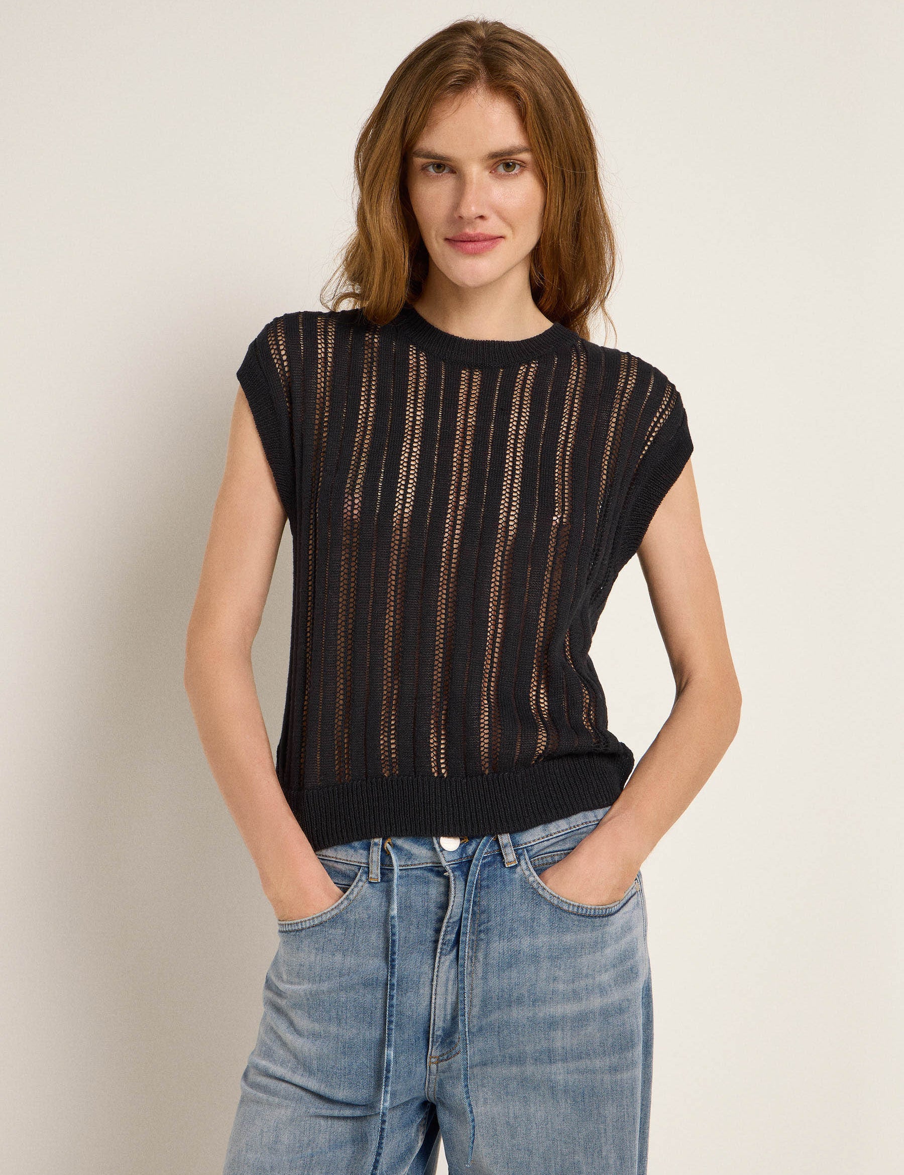 Frau in schwarzem Strickoberteil und Jeans