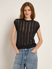 Frau in schwarzem Strickoberteil und Jeans