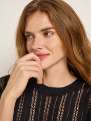 Nachdenkliche Frau in schwarzem Strickpullover
