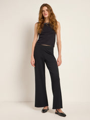Frau in eleganter schwarzer Hose und Top