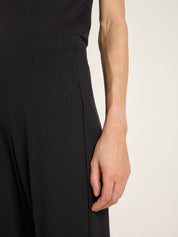 Detailaufnahme von Arm in schwarzer Rippstrickkleidung