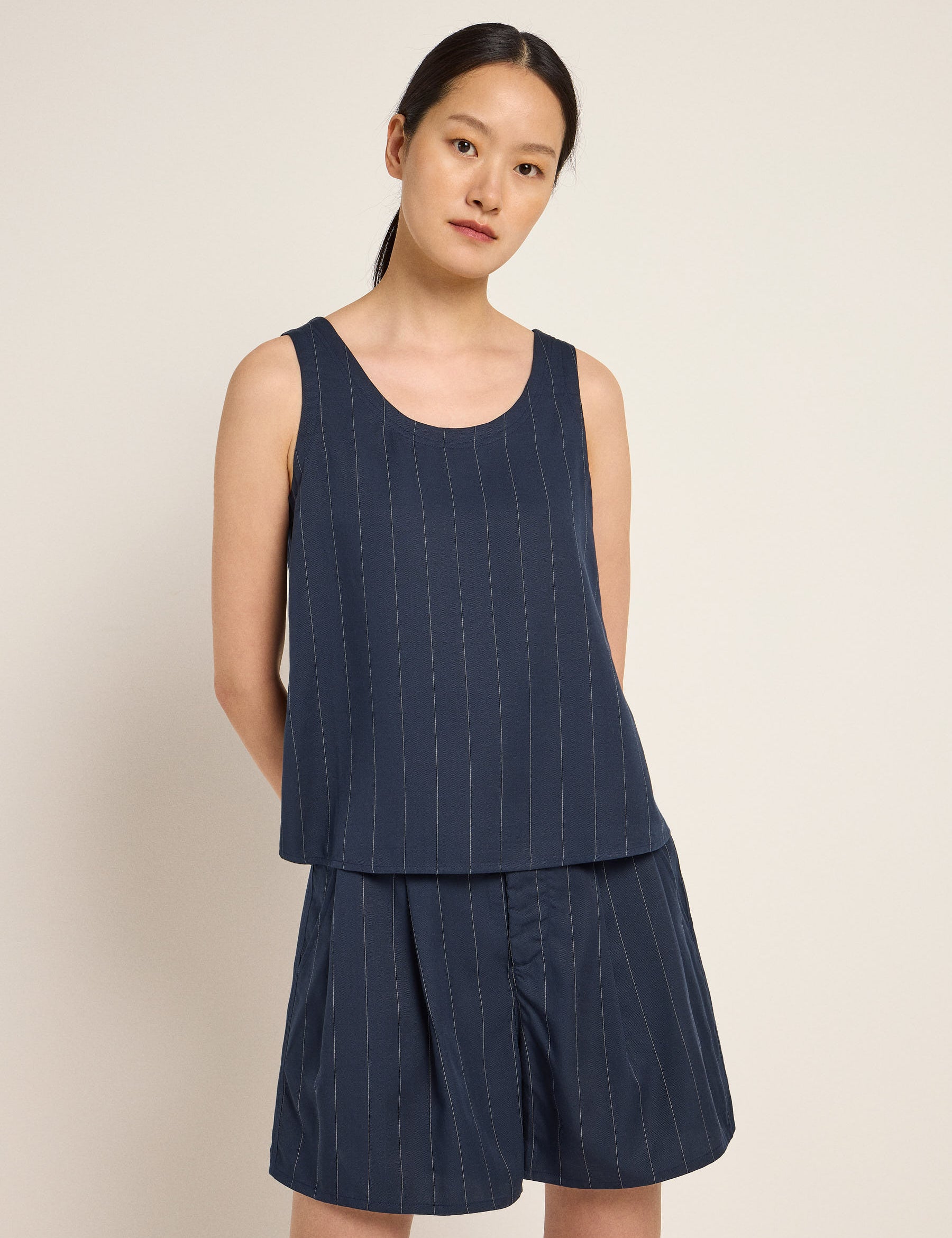 Frau in blauem gestreiftem Outfit steht