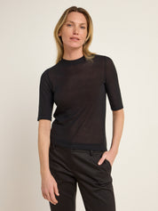 Frau in schwarzem Oberteil und Hose
