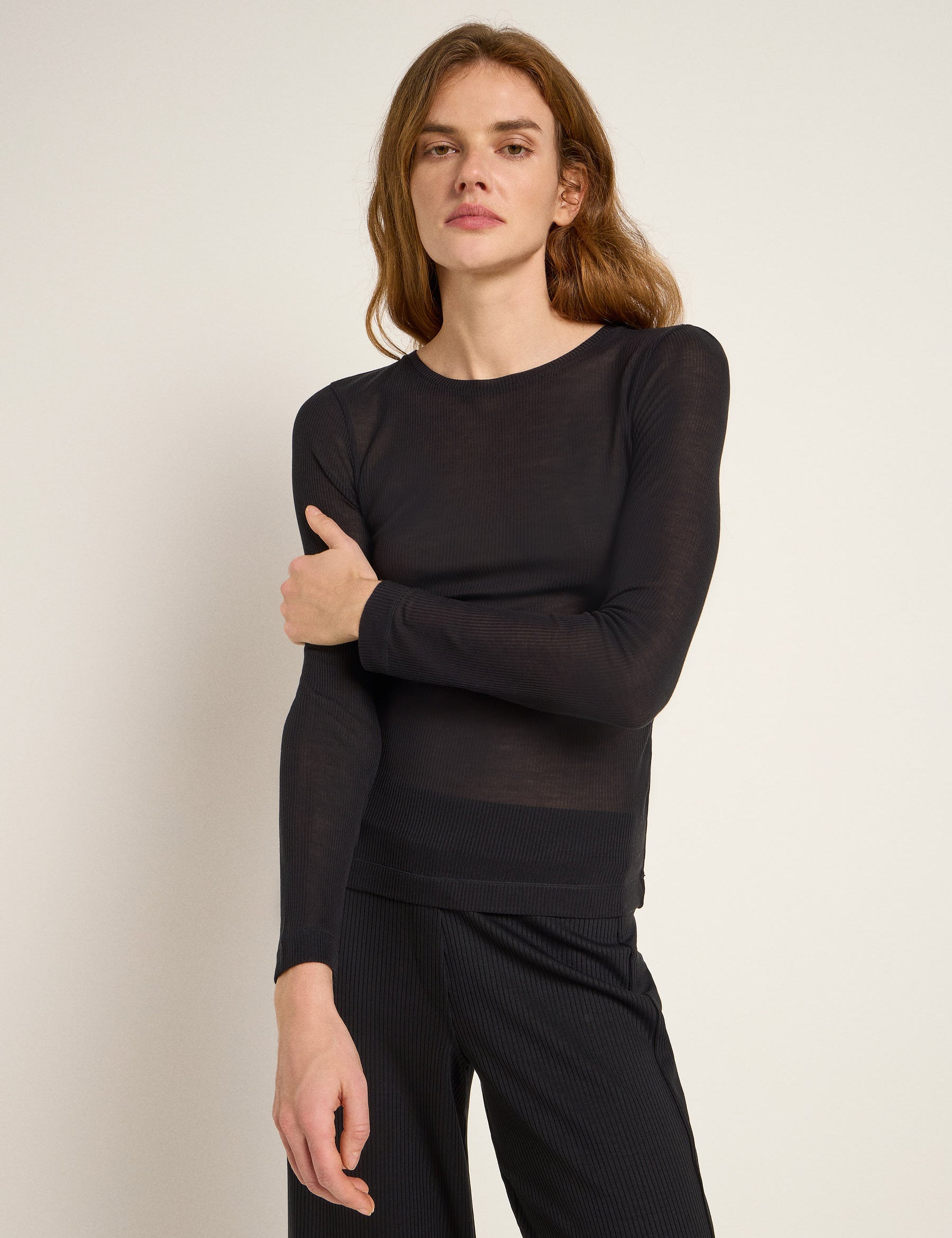 Frau in schwarzem Langarmshirt und Streifenhose