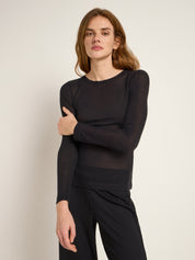 Frau in schwarzem Langarmshirt und Streifenhose