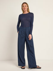 Frau in blauem Oberteil und gestreifter Hose
