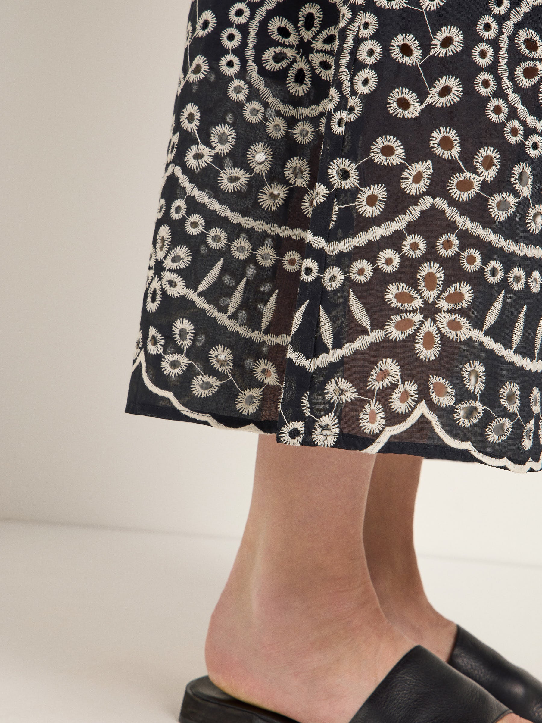 Bestickter Rock und schwarze Schuhe Detailaufnahme