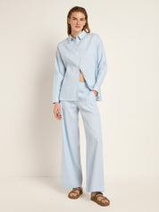 Frau in blauem Hemd und weit geschnittener Hose