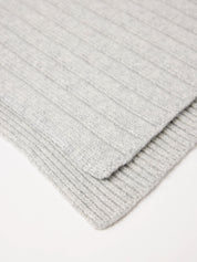 Grauer gestrickter Wollschal auf weißem Hintergrund