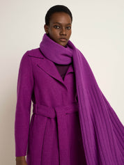 Frau in elegantem lila Mantel und Schal