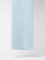 Blaue gestrickte Wolldecke an weißer Wand