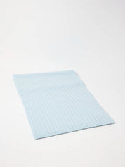 Hellblaues, geripptes Stoffstück auf weißem Hintergrund