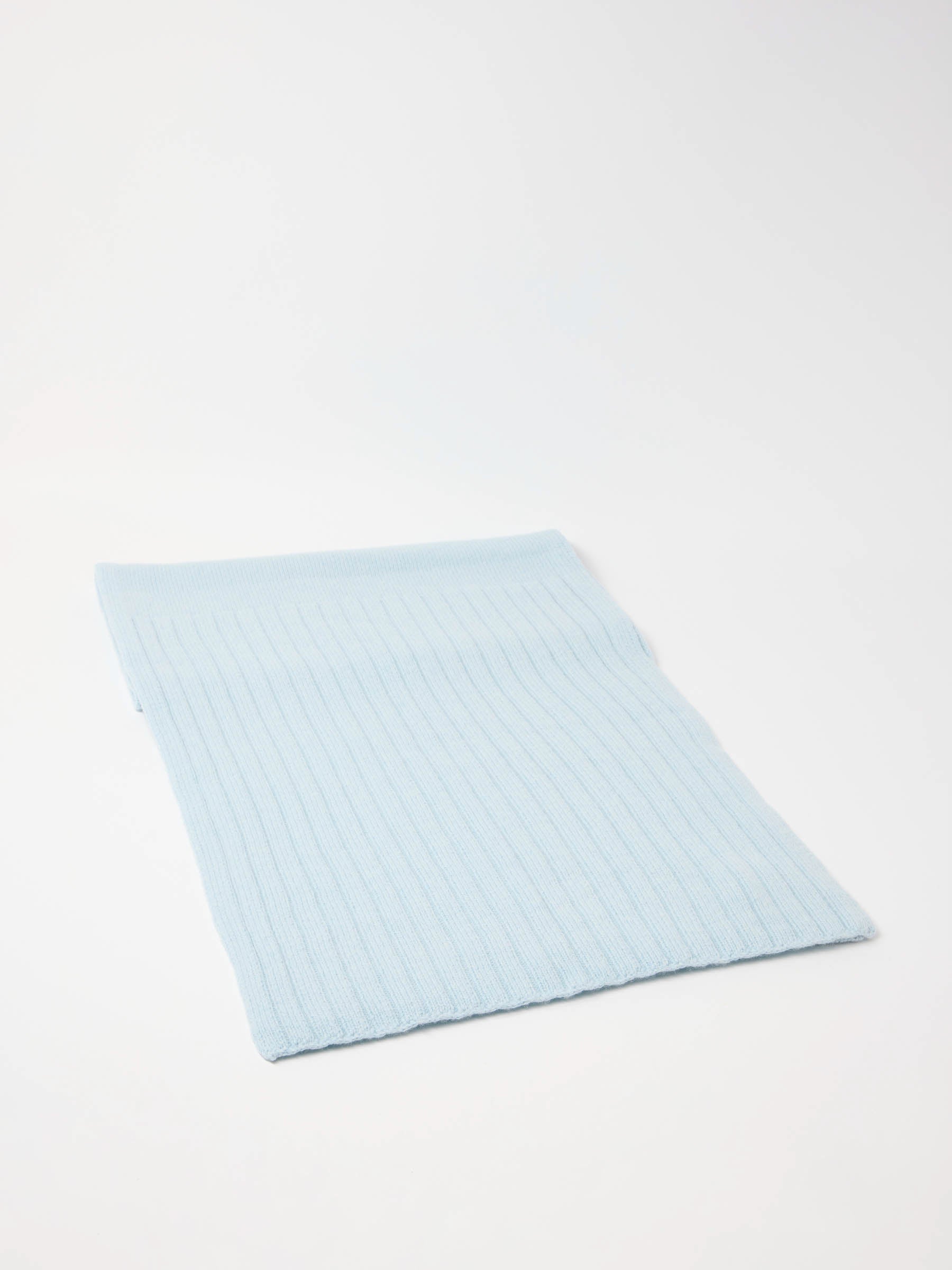 Hellblaues, geripptes Stoffstück auf weißem Hintergrund