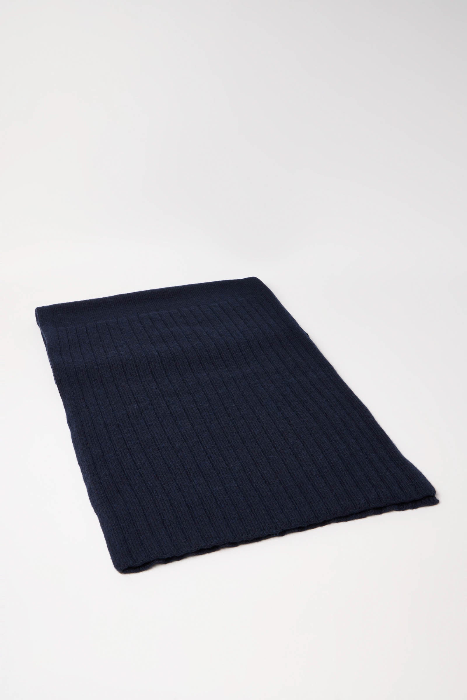 Dunkelblaue gestrickte Wolldecke auf weißem Hintergrund