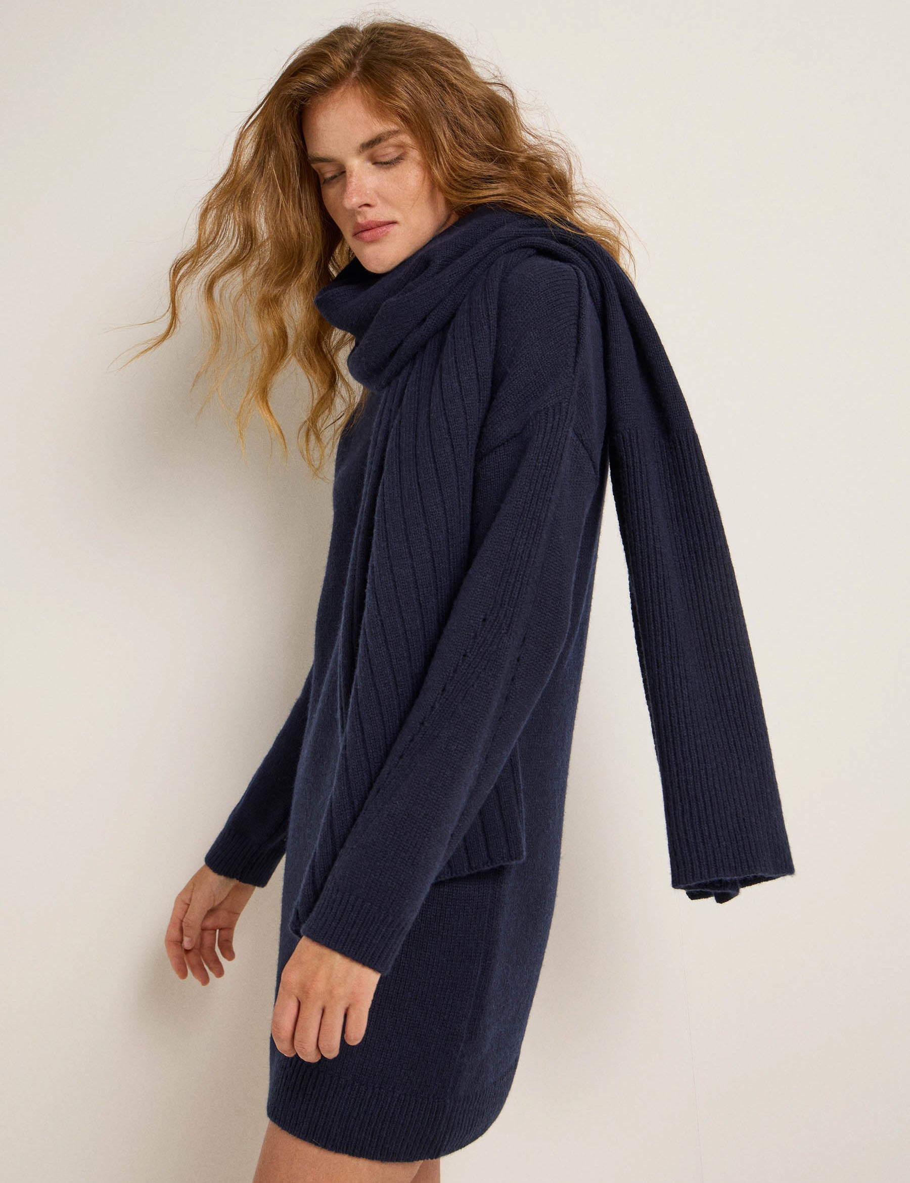 Frau mit blauem Strickkleid und Schal