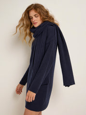 Frau mit blauem Strickkleid und Schal