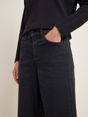 Person in schwarzer Jeans und Rippenpullover