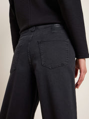 Person trägt schwarze Jeans und schwarzes Top