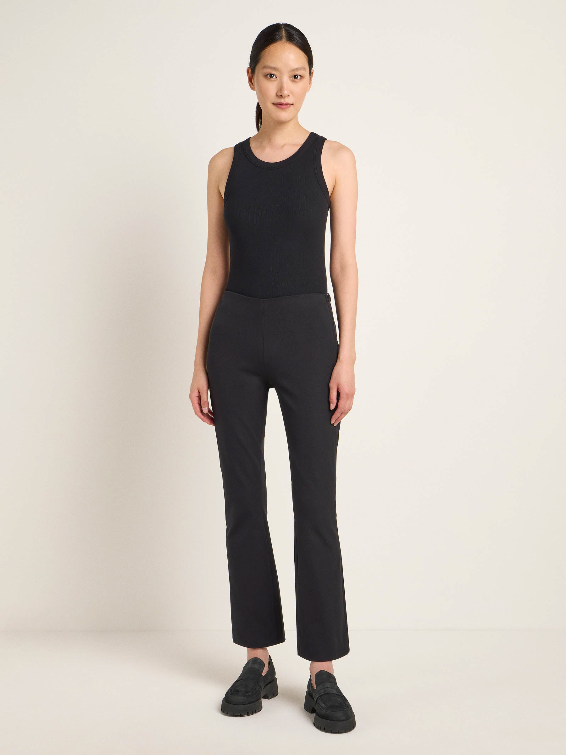 Frau in schwarzem Top und Hose posiert