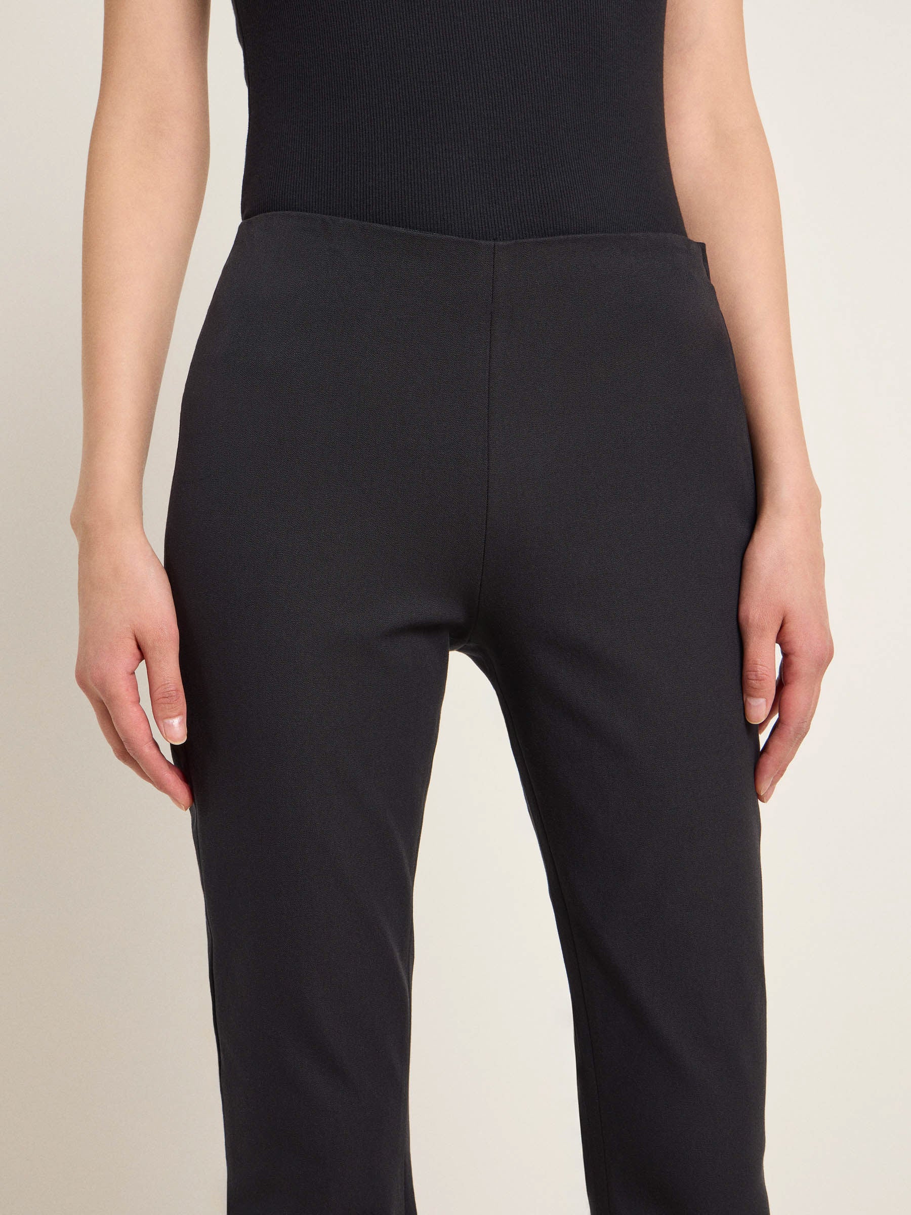 Frau in schwarzer Hose, Rückenansicht