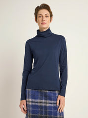 Frau in blauem Rollkragenpullover und Karorock