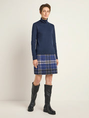 Frau in Rollkragenpullover und kariertem Rock